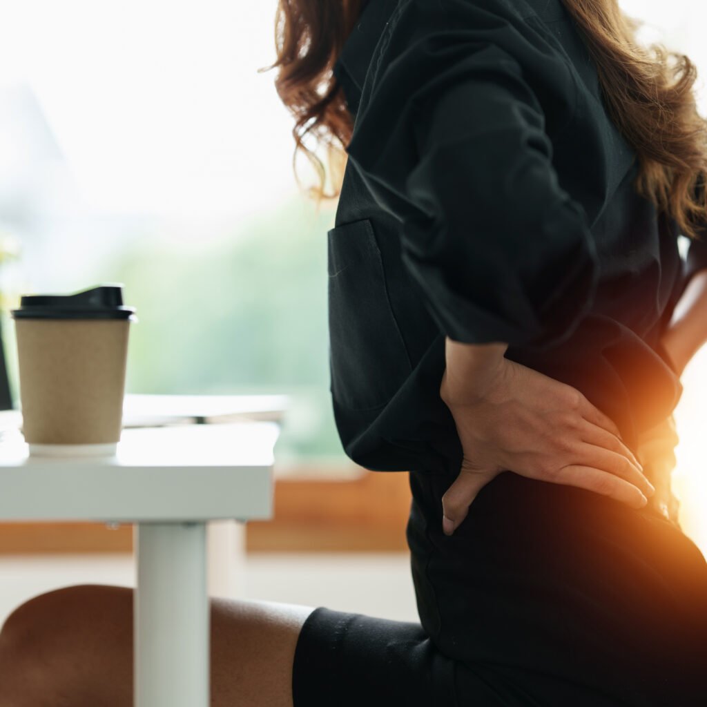 Femme se tenant le dos en raison d'une dorsalgie